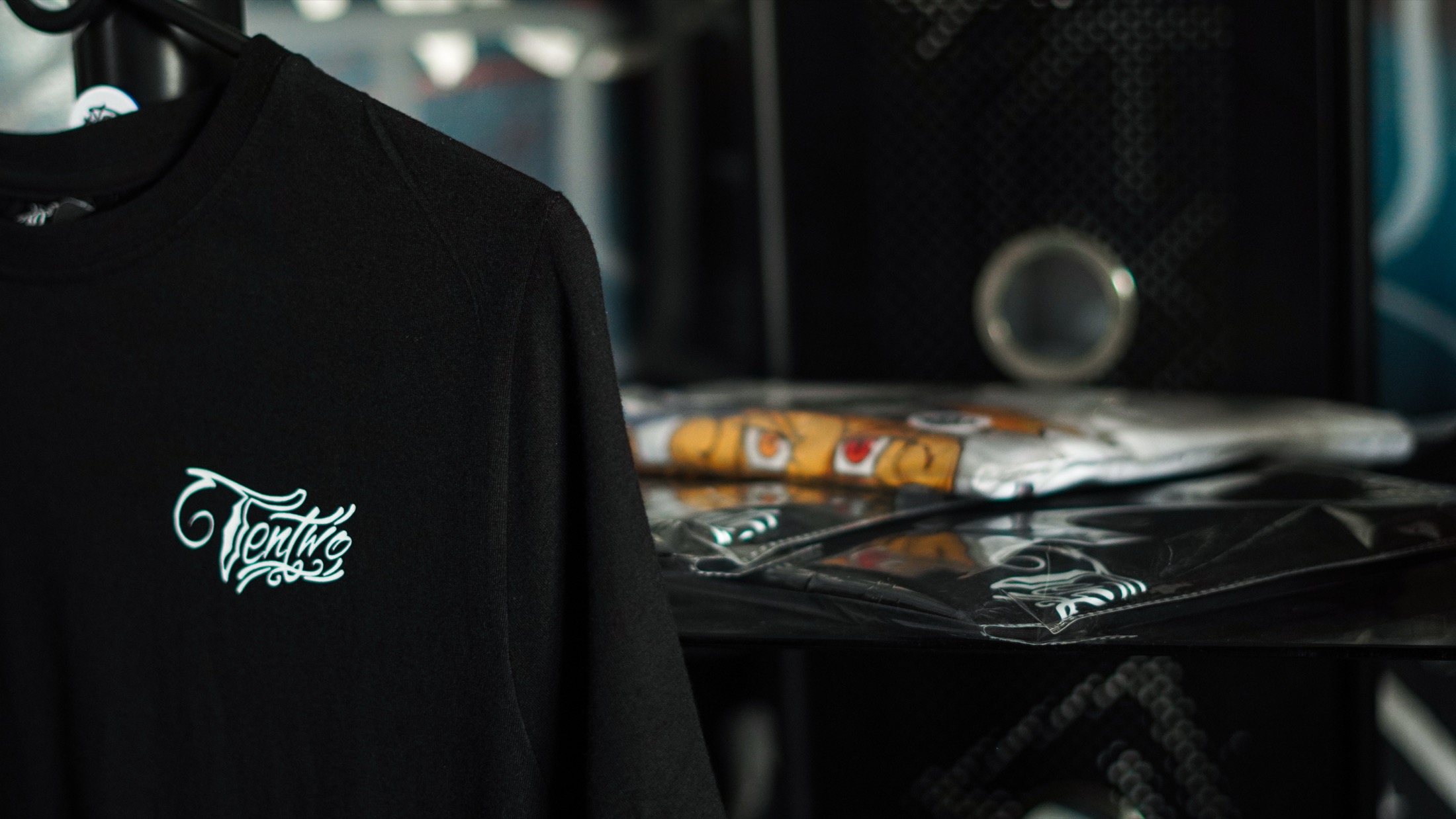 Black TenTwo tee styled in the studio with folded merchandise