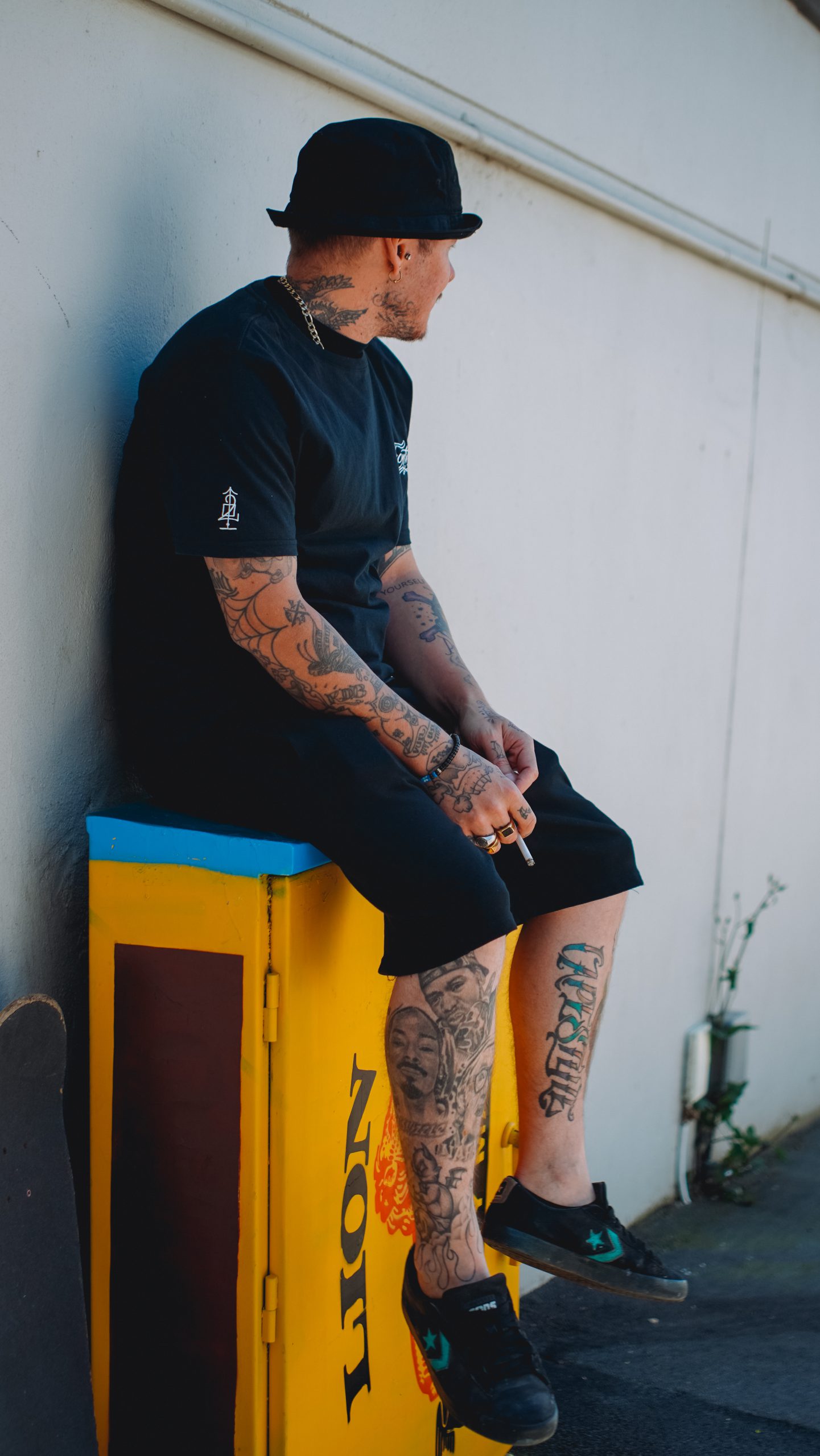 Damian seated outdoors against a wall